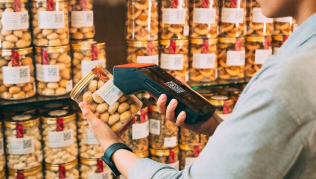 Close up of a smart packaging label with glowing NFC chip QR code scanning to AR product demo on smartphone and data visualization dashboard showing supply chain tracking