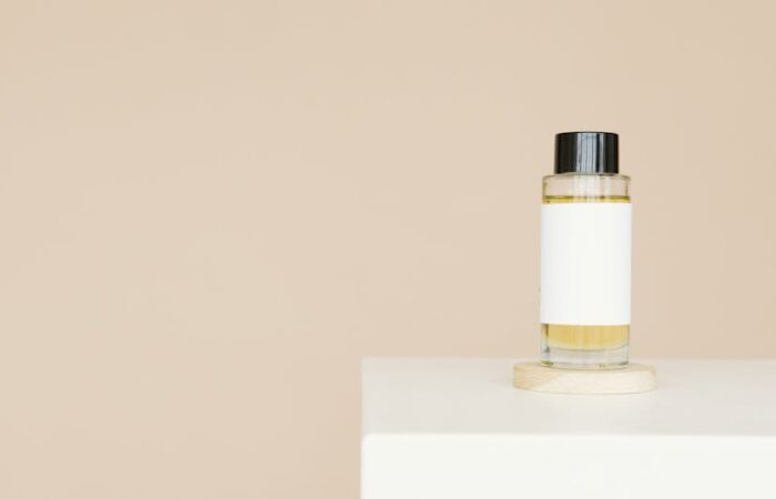 Elegant minimalist paper box for skincare serum with soft curved edges frosted glass bottle inside neutral tones and subtle embossed logo on a clean white background