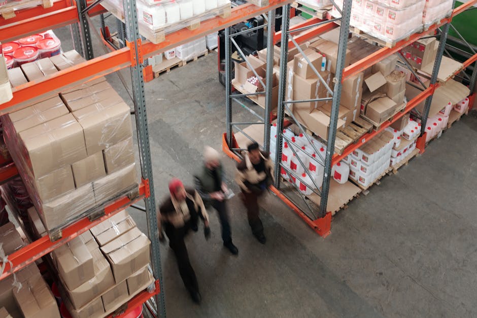 Warehouse scene with staff packing products into mailers on one line and boxes on another showing speed and space differences