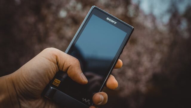 Modern senior friendly pill bottle with ergonomic grip ridges large high contrast labels and easy open mechanism held by an elderly hand demonstrating ease of use