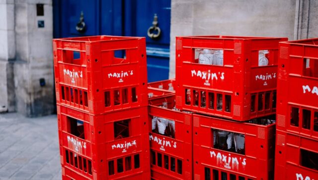 Vibrant cityscape at dusk with delivery trucks e commerce packages stacked on sidewalks and diverse urban consumers unboxing branded products emphasizing fast paced urban delivery and customization