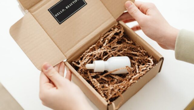 Vibrant unboxing scene of a custom printed mailer box for a DTC beauty subscription showing colorful branding product reveal and excited customer hands